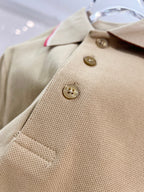 Tan polo shirt close-up of button placket with two gold buttons