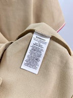 Tan polo shirt care label inside collar with text and size info