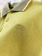 Olive green polo fabric with embroidered logo near button placket and cuff trim