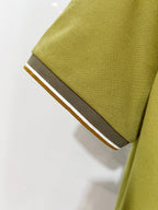 Olive green polo sleeve cuff with contrast dark trim and edge stripe