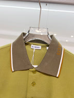 Olive green polo shirt with pointed collar, dark brown placket, and button detail