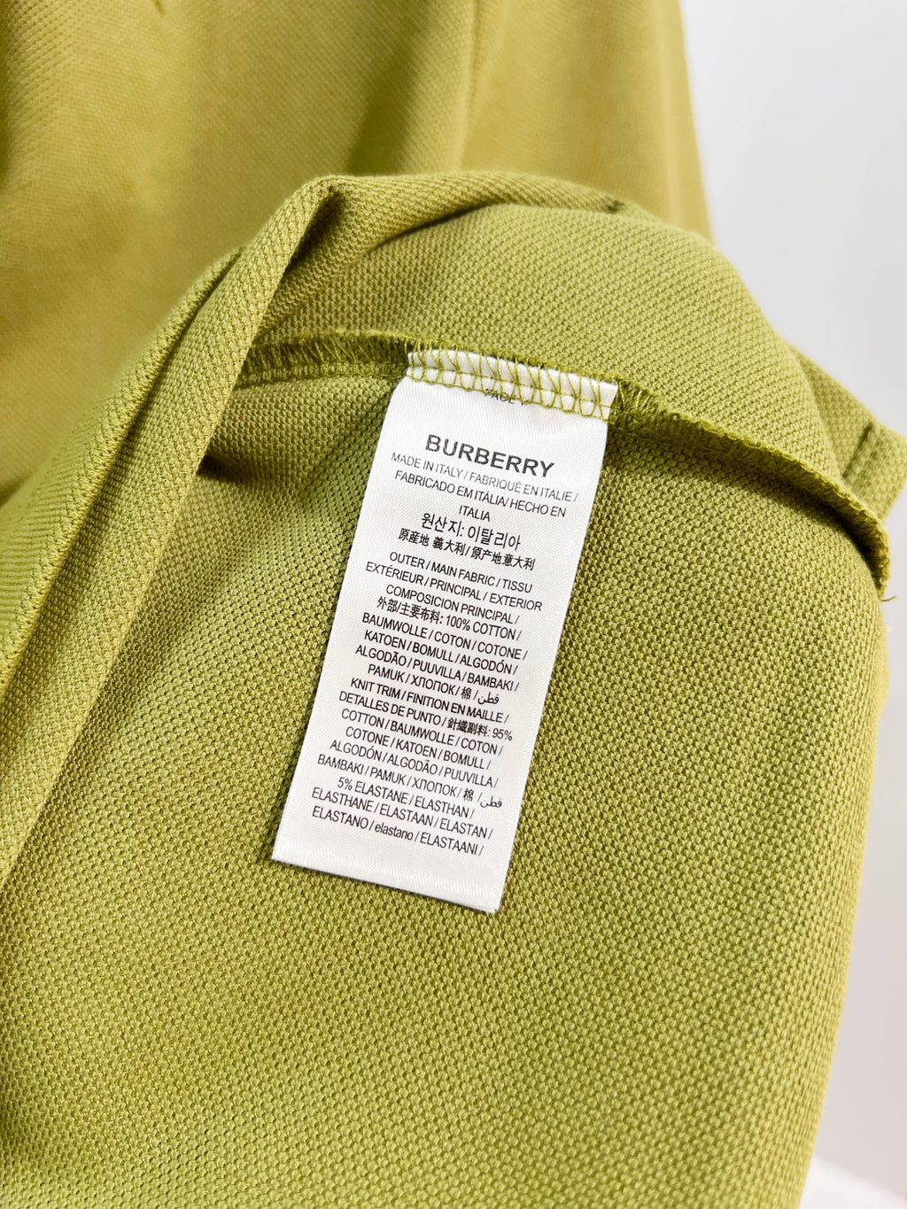Olive green polo care label at inner collar seam