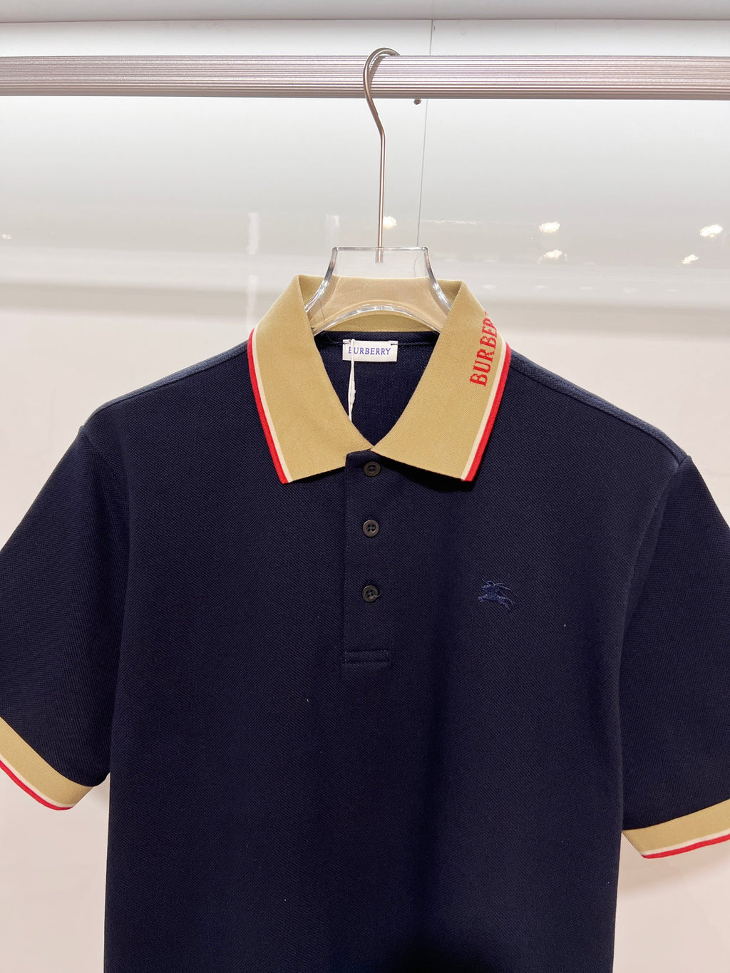 Navy Burberry polo shirt with contrast beige collar and red-trim stripe