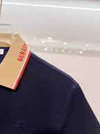 Dark blue Burberry polo shirt with small horse logo on sleeve and striped collar