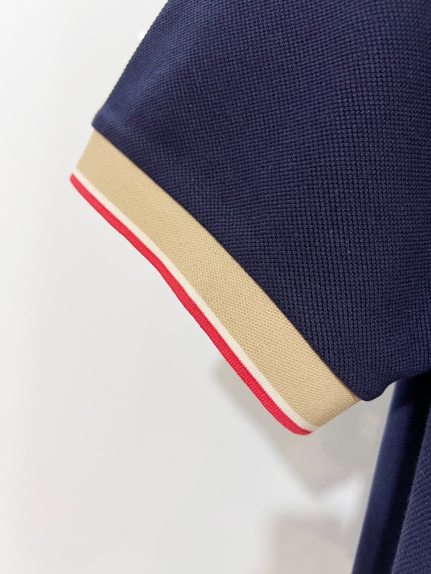 Burberry polo shirt sleeve cuff with beige trim and red stripe