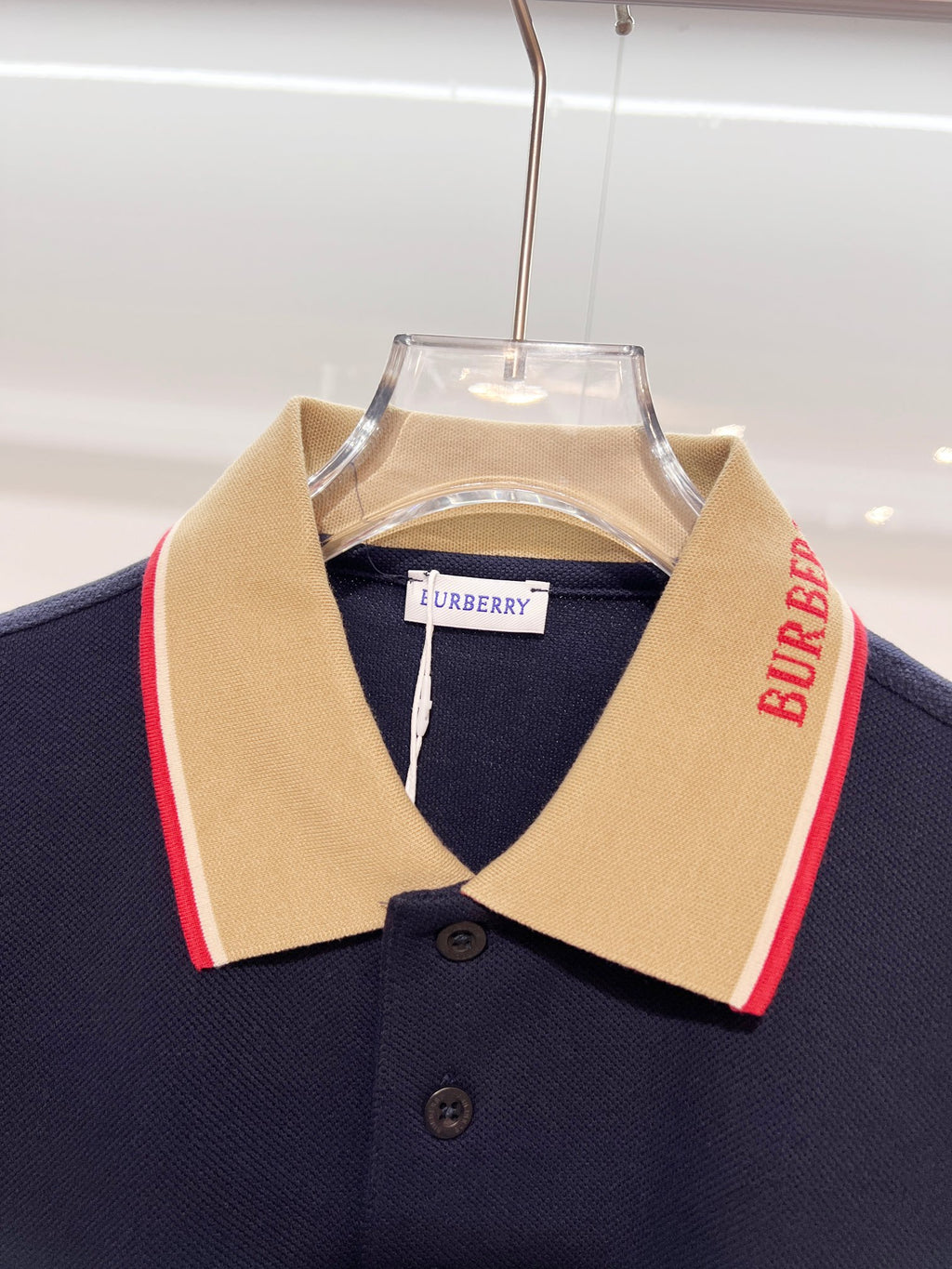 Dark blue Burberry polo shirt neckline with beige collar and red side stripe