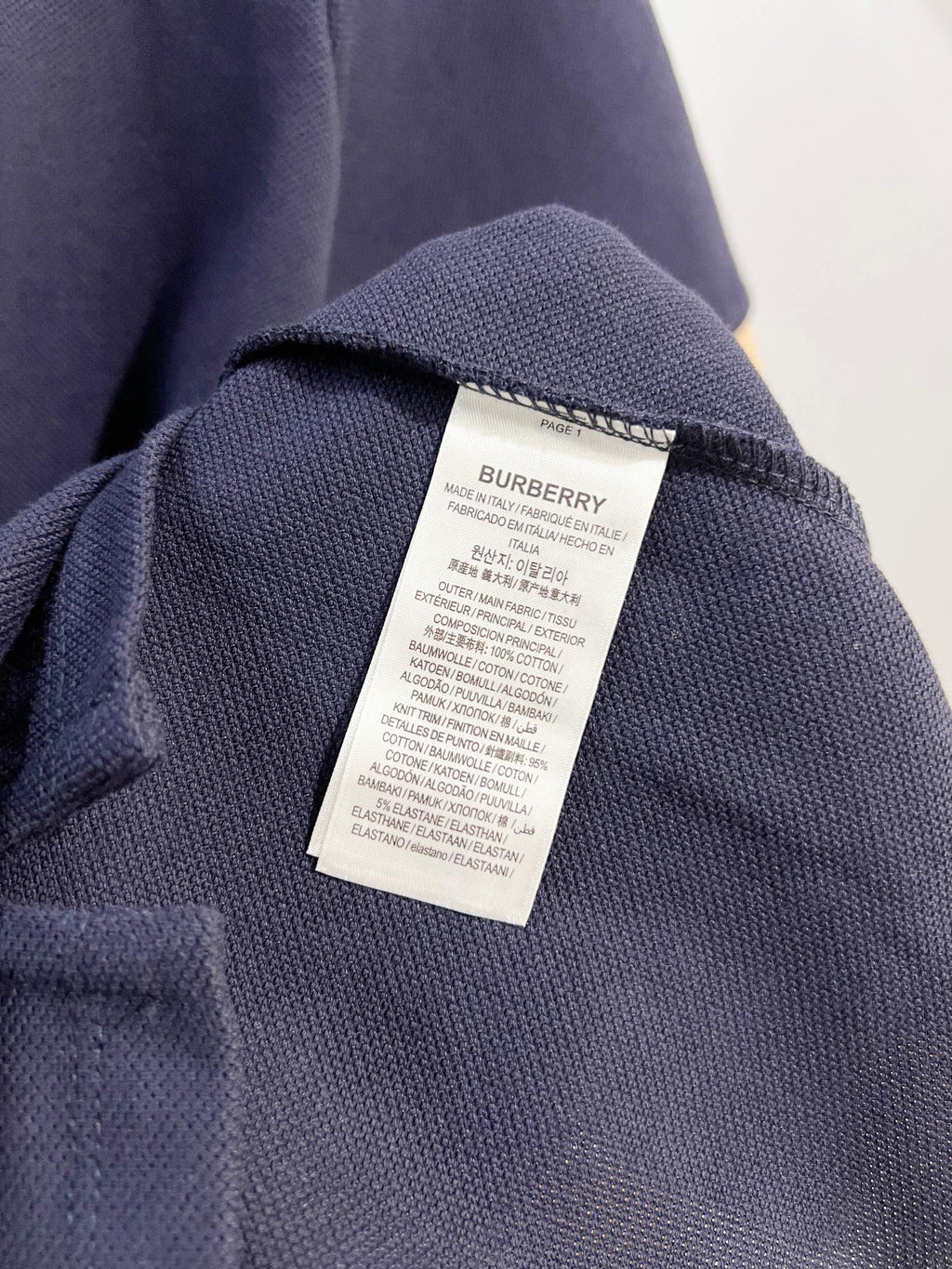 Burberry polo shirt care label on dark blue knit fabric