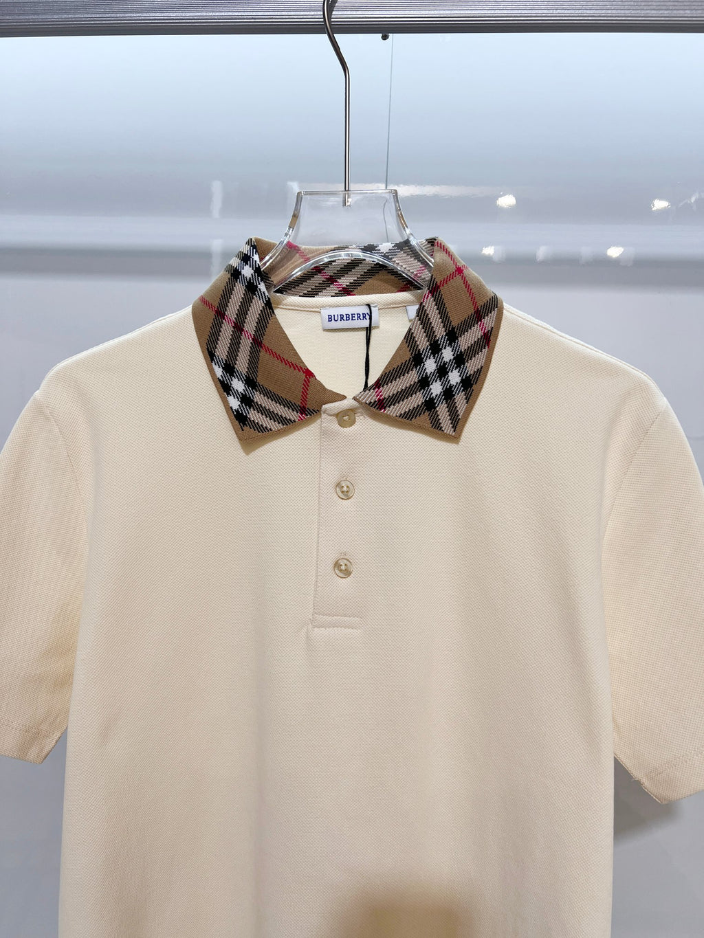 Cream short-sleeve polo shirt with Burberry check collar and gold buttons