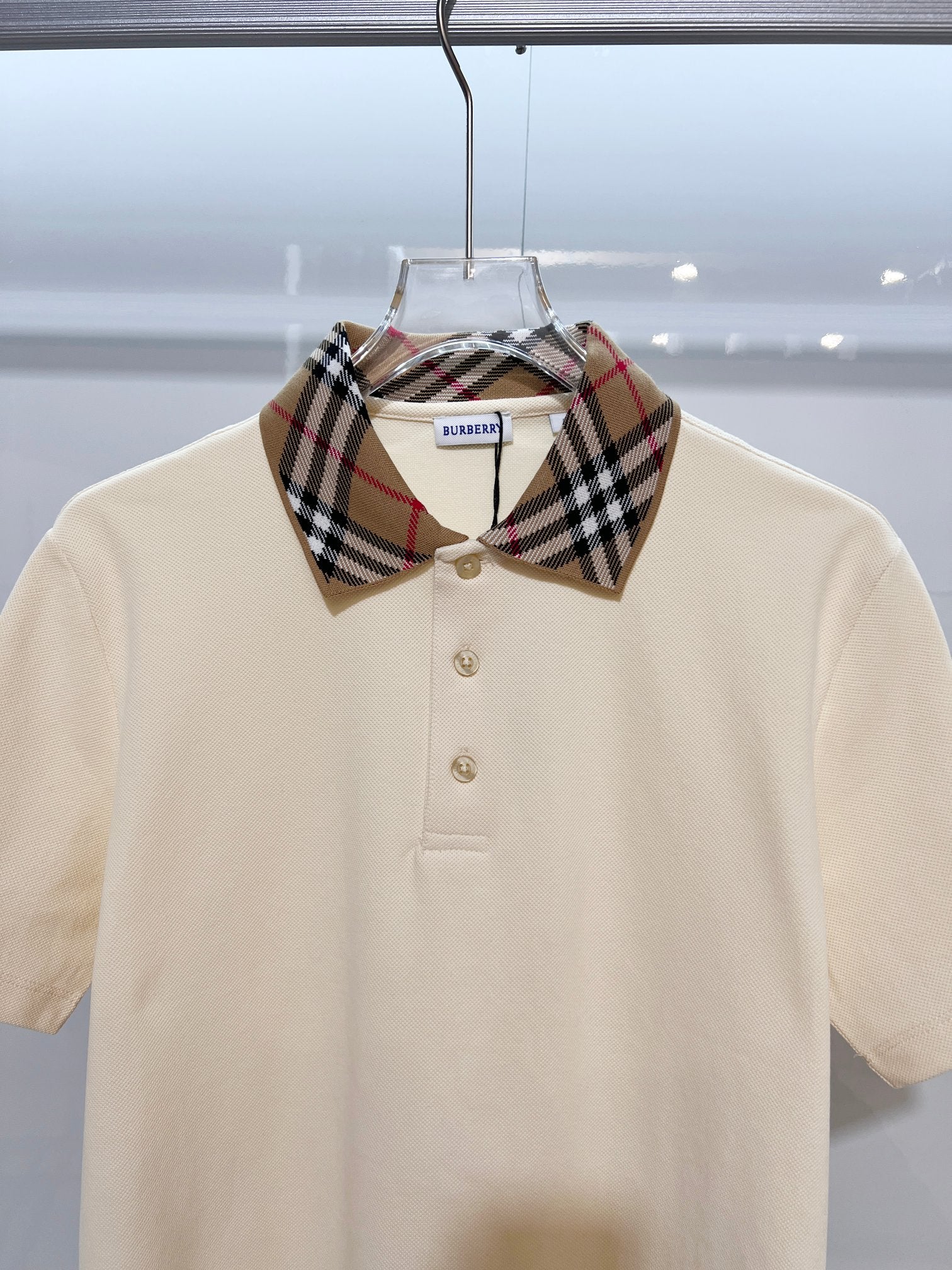 Cream short-sleeve polo shirt with Burberry check collar and gold buttons