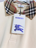 Cream polo shirt with check collar trim and attached Burberry tag
