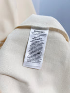 Cream polo shirt care label patch on inner collar seam