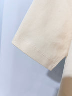 Cream short-sleeve polo shirt fabric close-up, collar edge visible