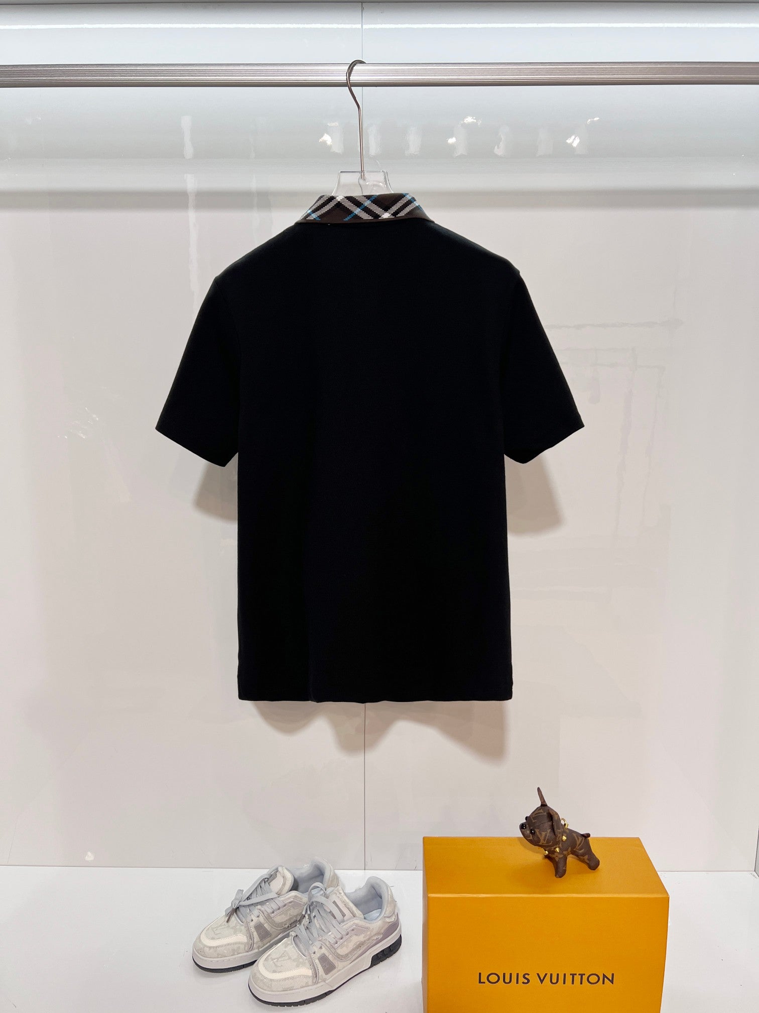 Black short-sleeve polo shirt back view with plaid collar detail