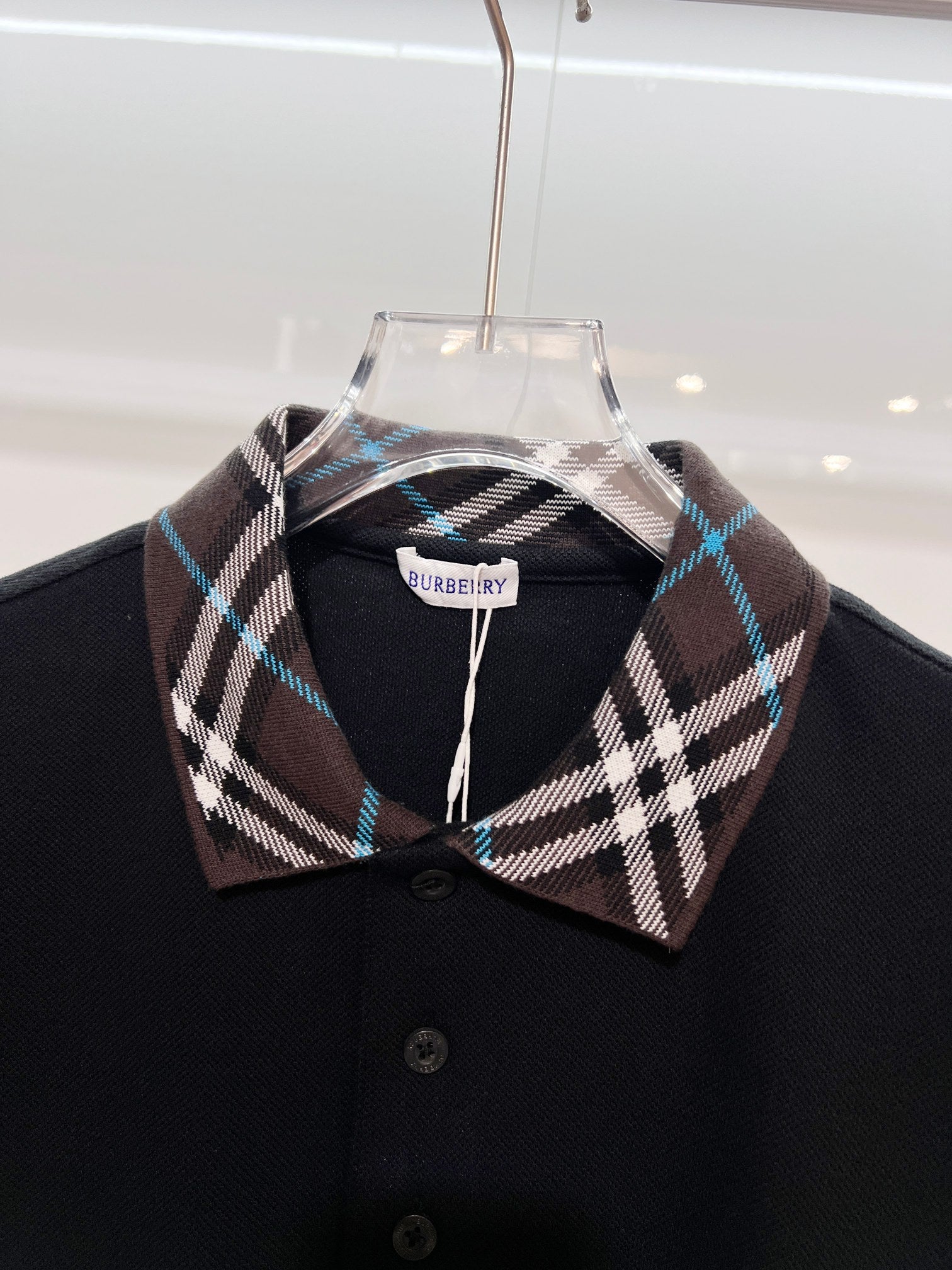 Black polo shirt with Burberry plaid collar and front button placket