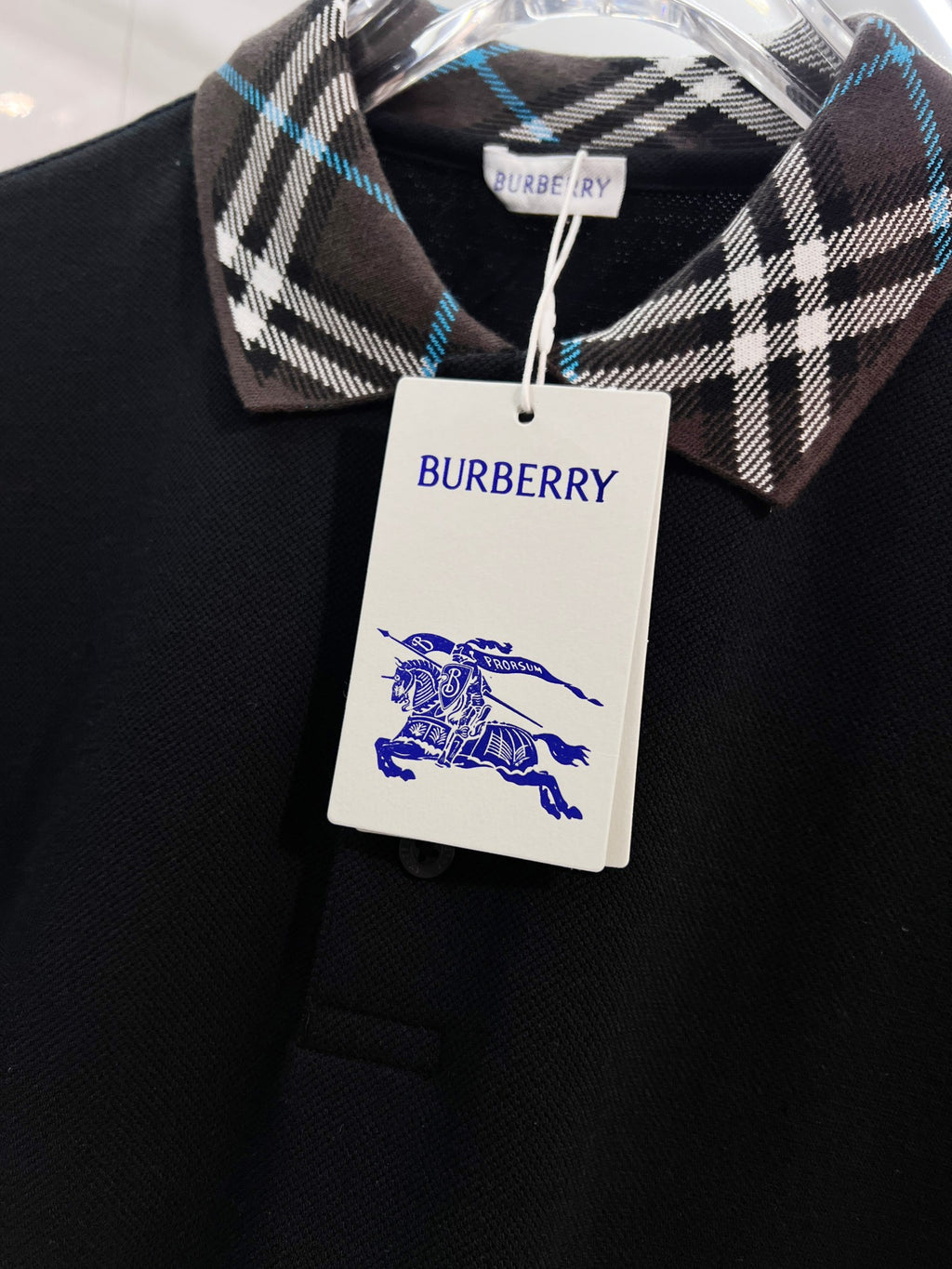 Black polo shirt with Burberry plaid collar and white hang tag
