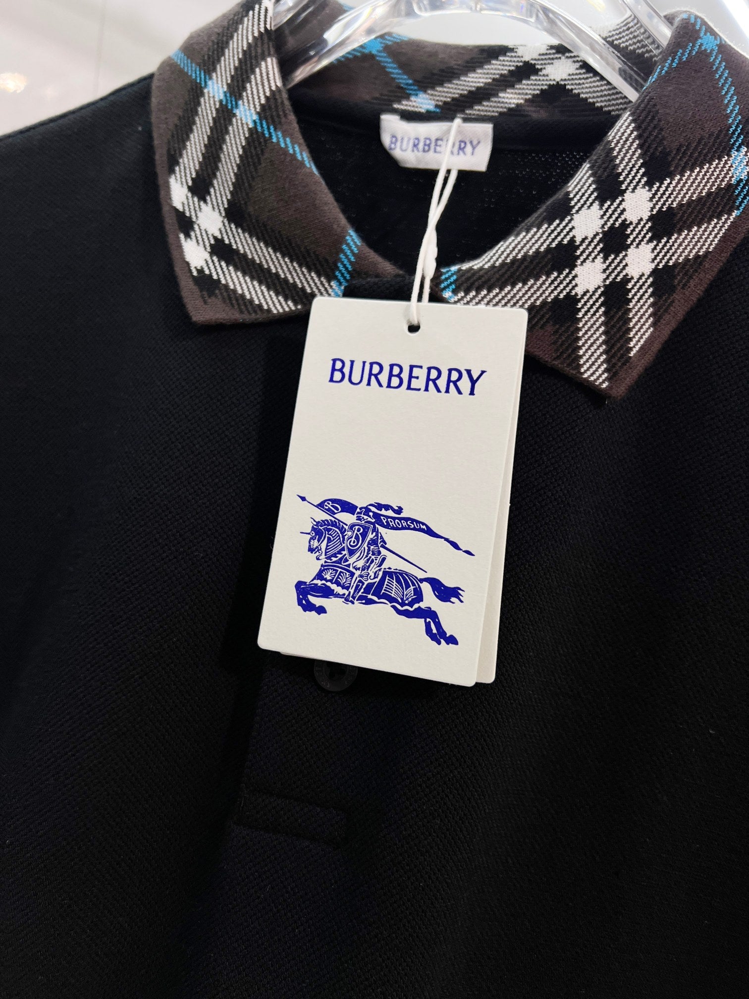 Black polo shirt with Burberry plaid collar and white hang tag