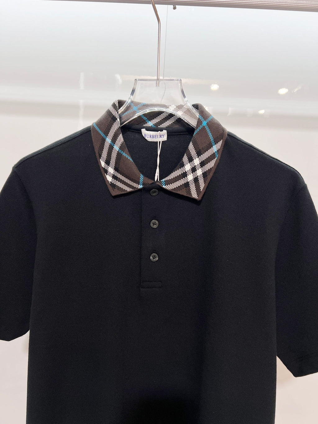 Black short-sleeve polo shirt with Burberry plaid pointed collar and button placket