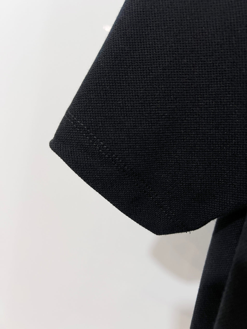 Black polo shirt sleeve with textured fabric and cuff edge