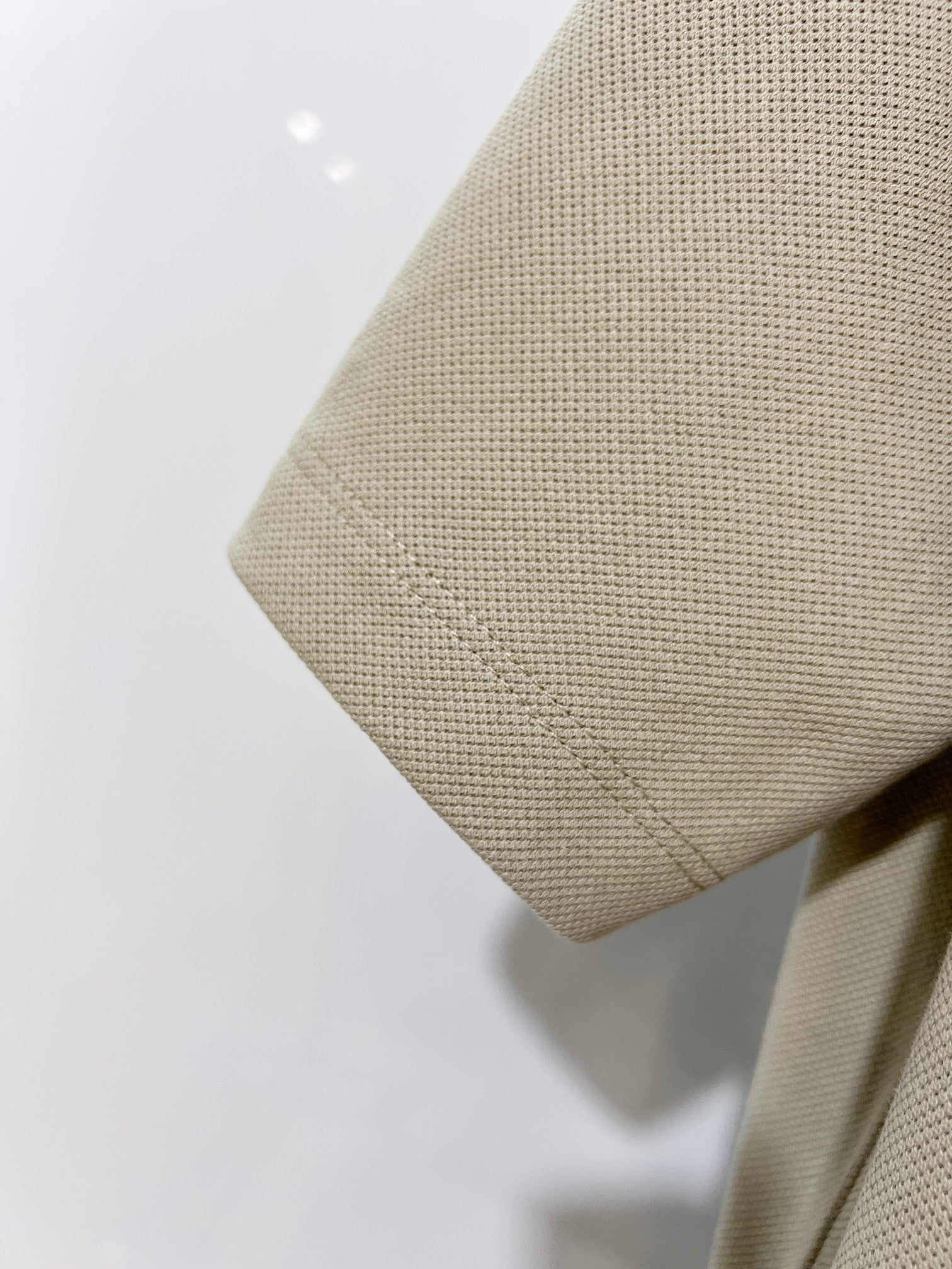 Beige polo shirt fabric with curved hemline