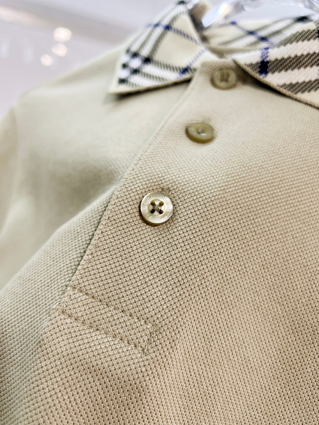 Beige polo shirt with gold buttons and checkered collar
