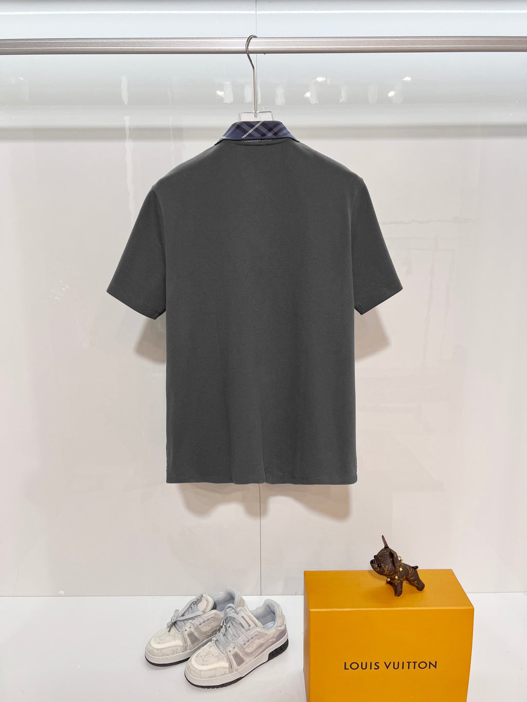 Mens short-sleeve polo shirt in dark gray, back view on display hanger