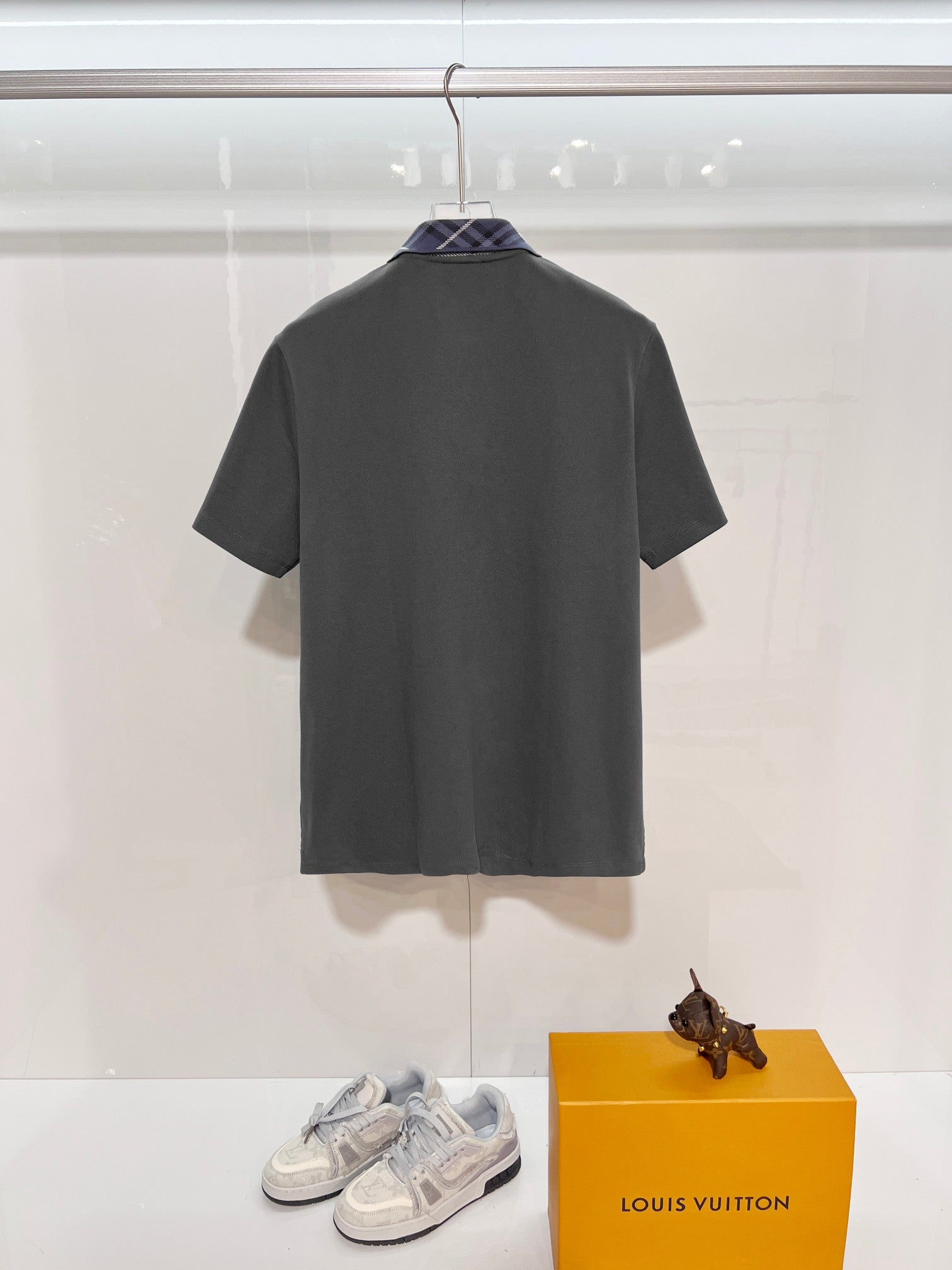 Mens short-sleeve polo shirt in dark gray, back view on display hanger