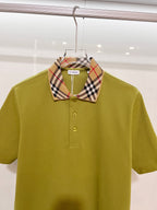 Olive green polo shirt with plaid check collar and buttoned front, close-up
