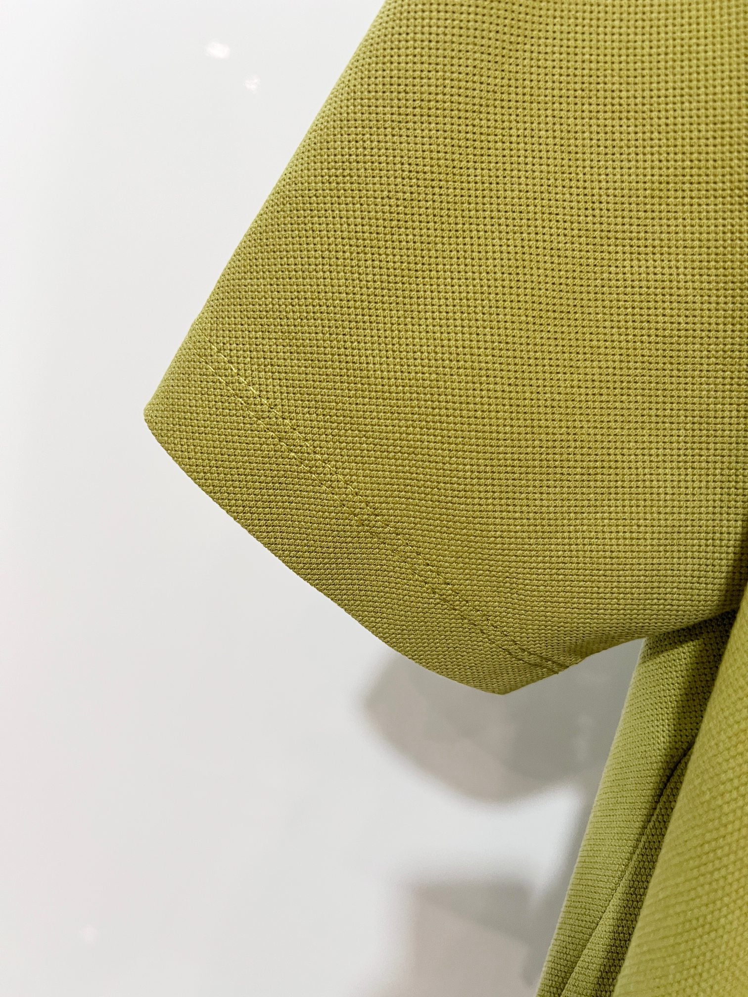 Olive green polo shirt sleeve hem detail