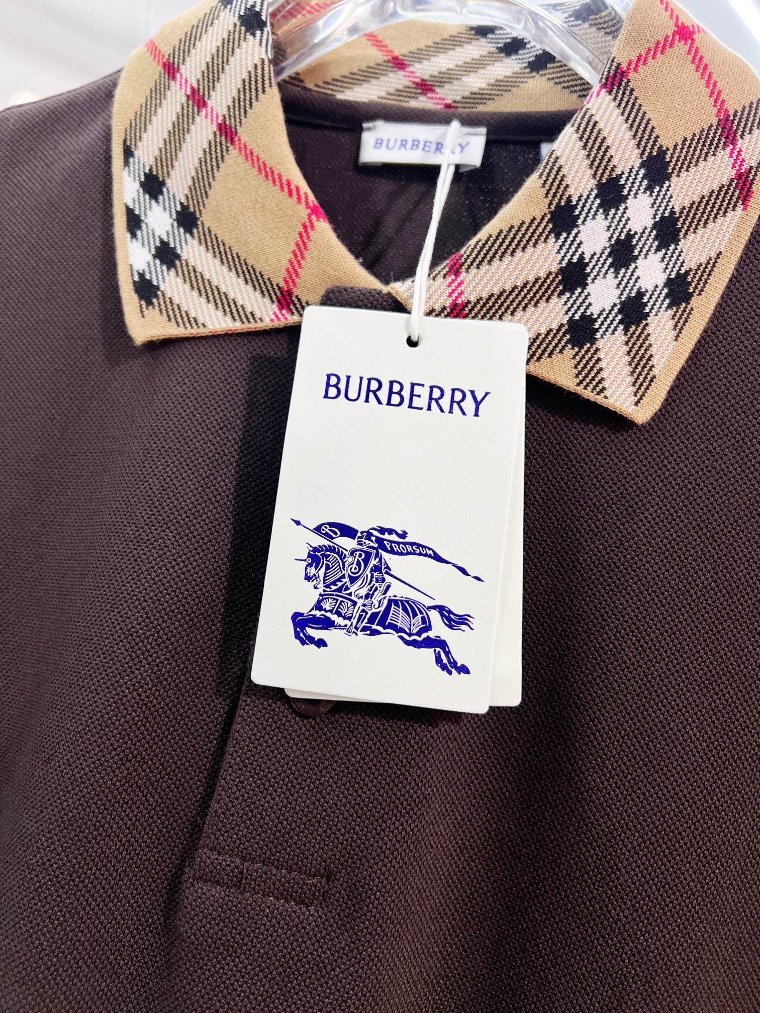 Burberry polo collar in beige tartan with navy and red stripes; logo tag
