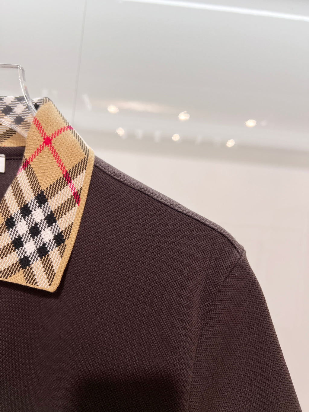 Burberry polo shirt, dark brown fabric with tartan collar corner on hanger