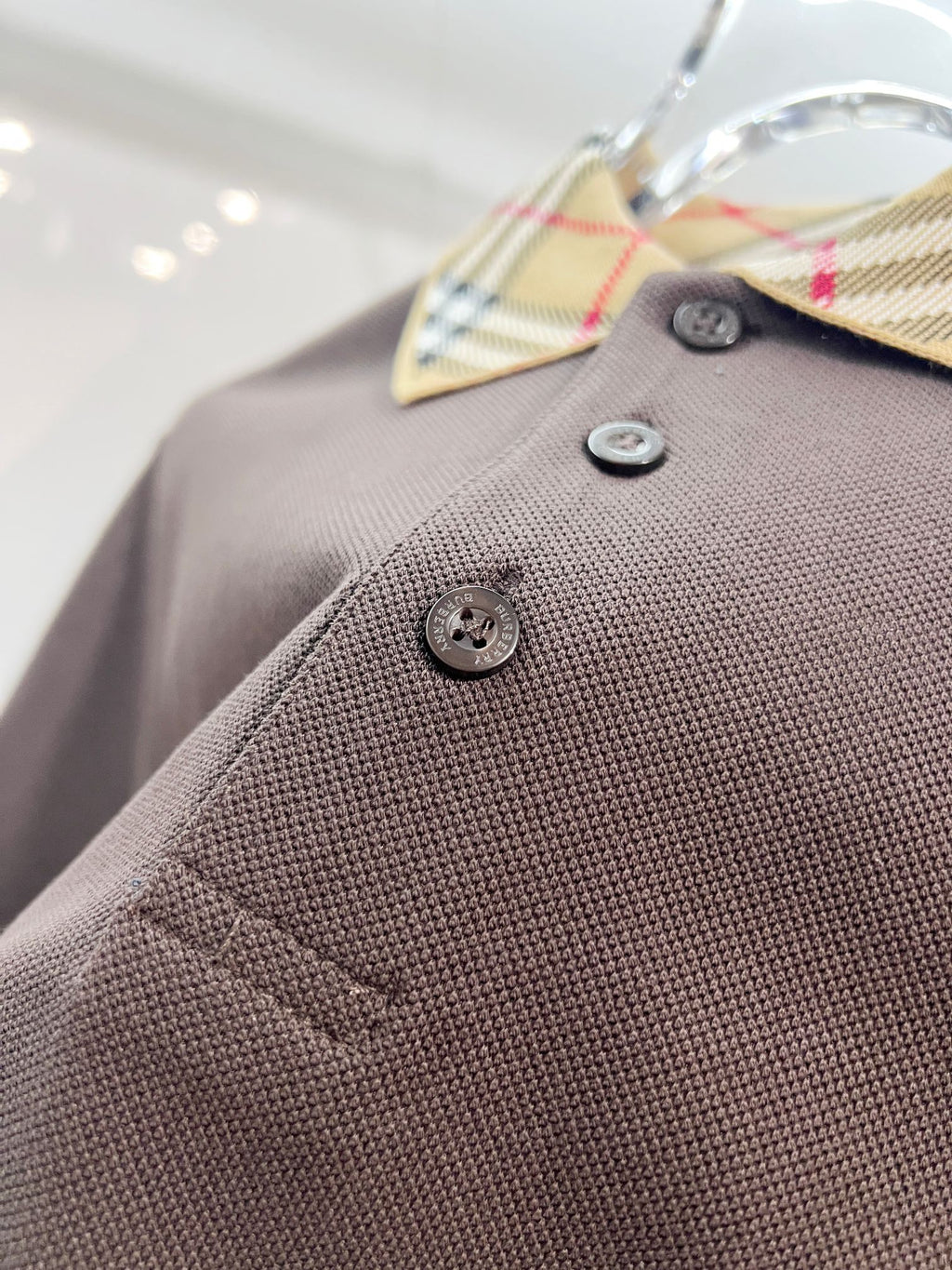 Burberry polo shirt close-up, dark brown textured knit with logo buttons