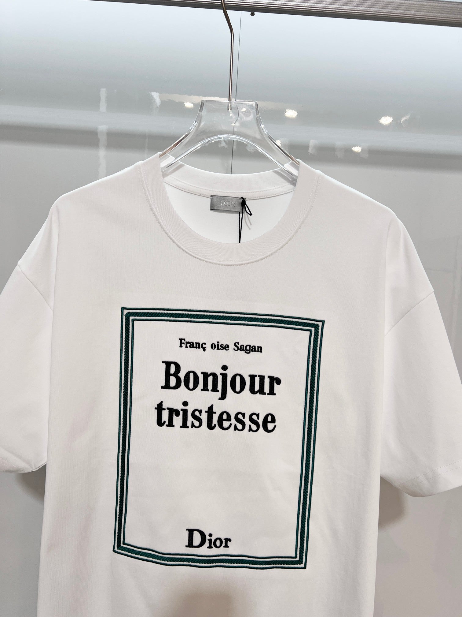White Dior graphic T-shirt close-up with “Bonjour tristesse” front print