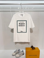 White Dior graphic T-shirt with green-bordered “Bonjour tristesse” front print