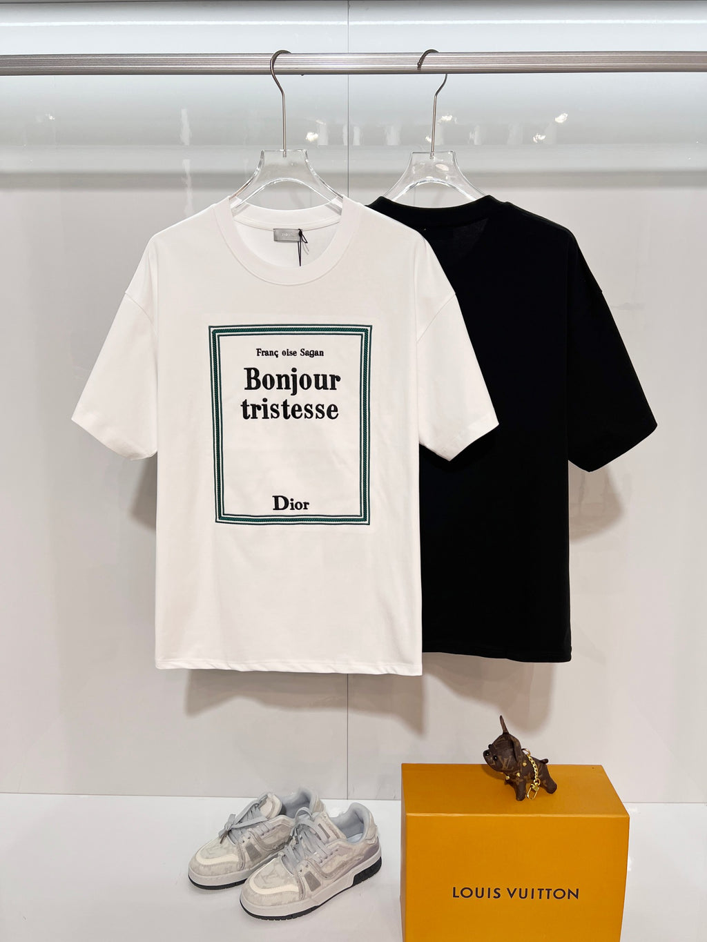 White Dior short-sleeve T-shirt with Bonjour tristesse graphic; black T-shirt behind