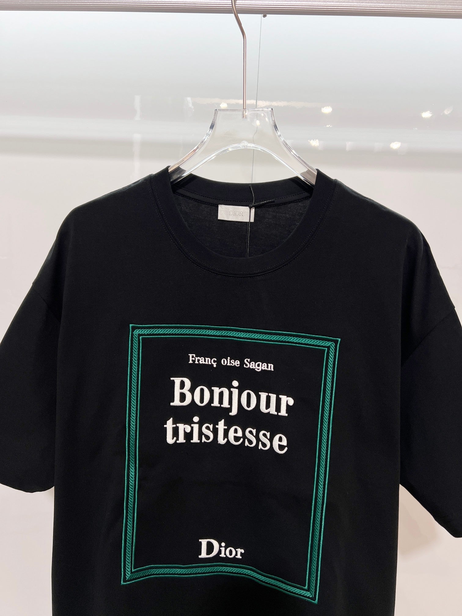 Black Dior T-shirt with 'Bonjour tristesse' logo graphic close-up