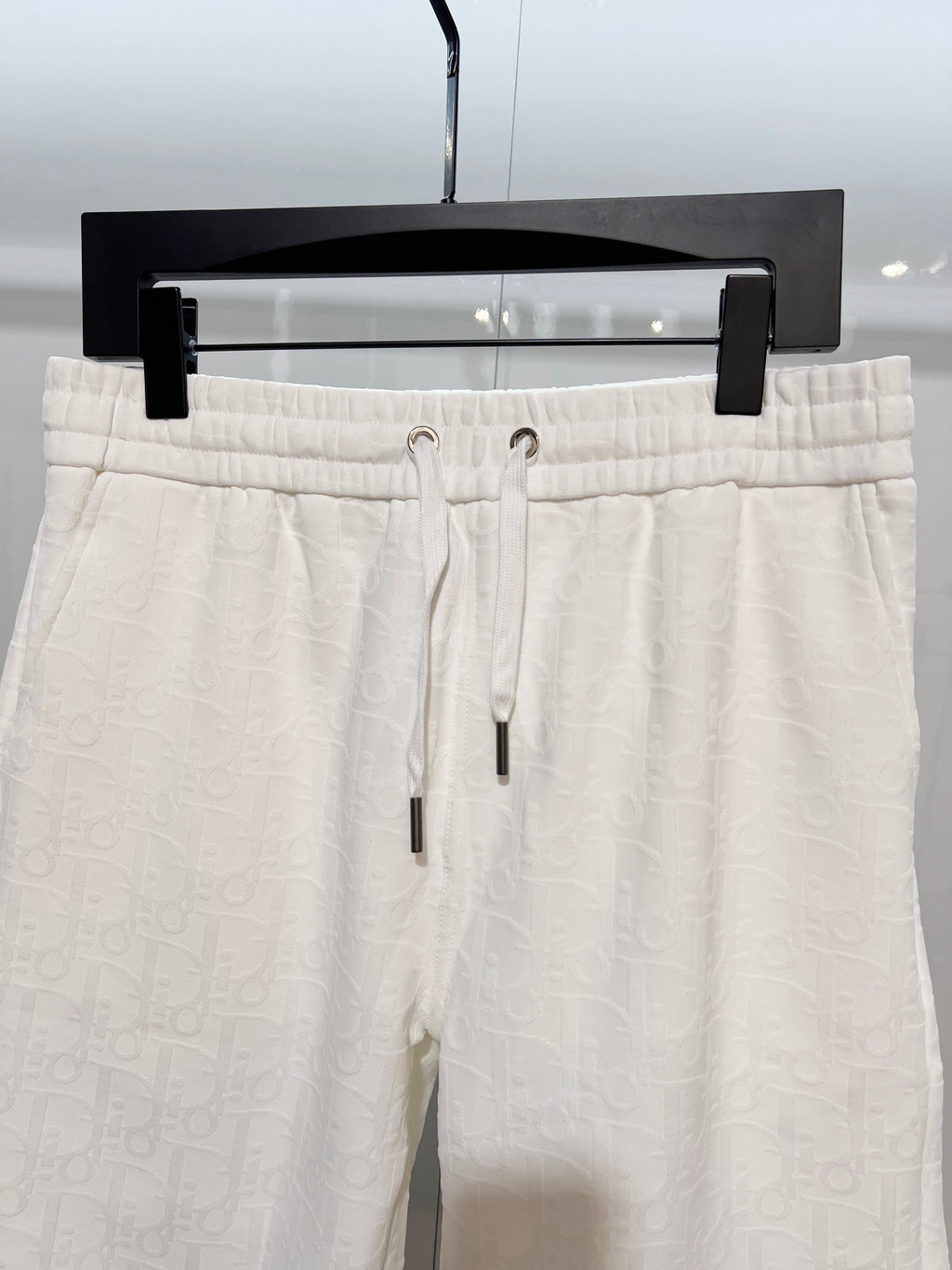 White drawstring shorts with ribbed waistband and metal eyelets