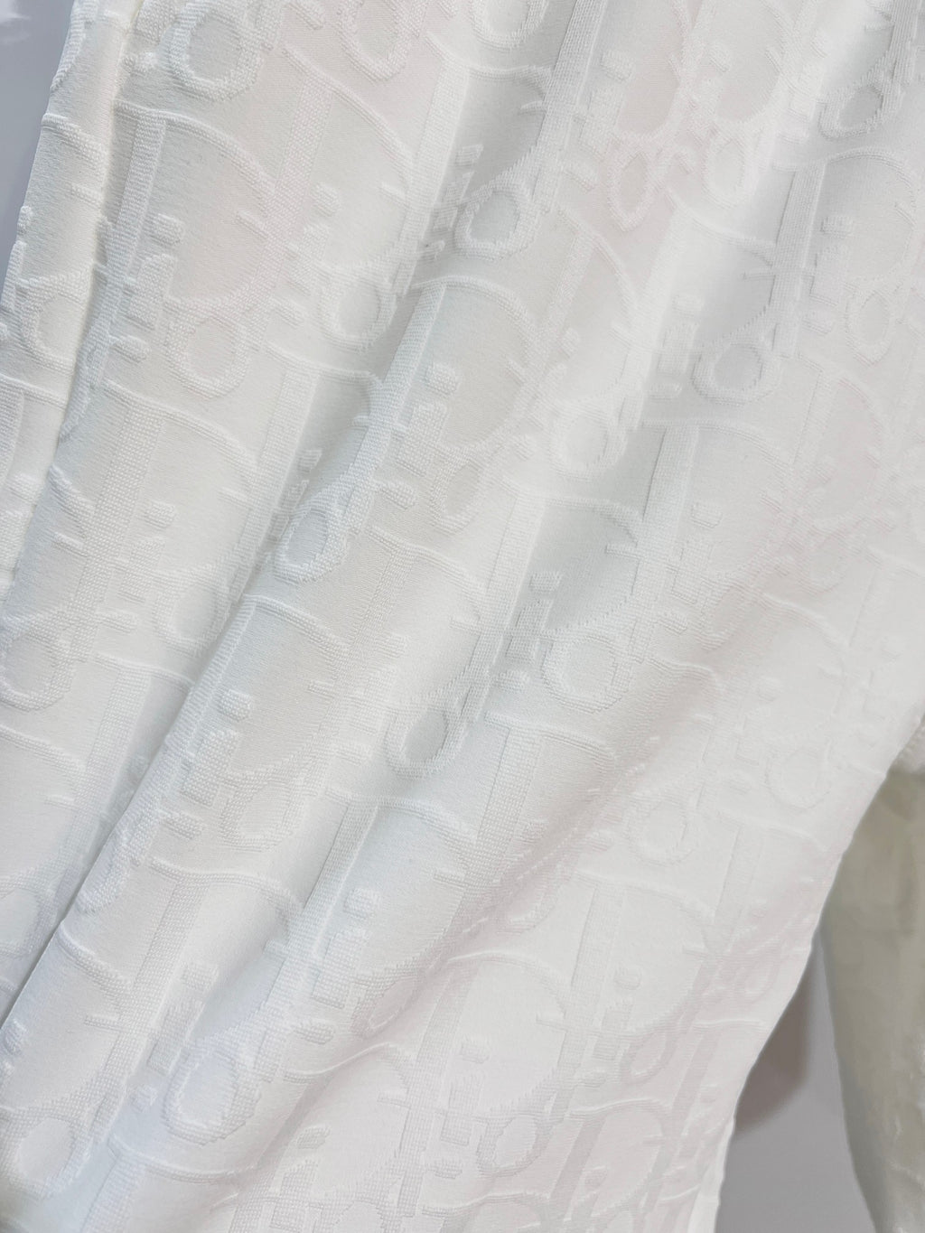White shorts fabric with subtle allover logo-style texture