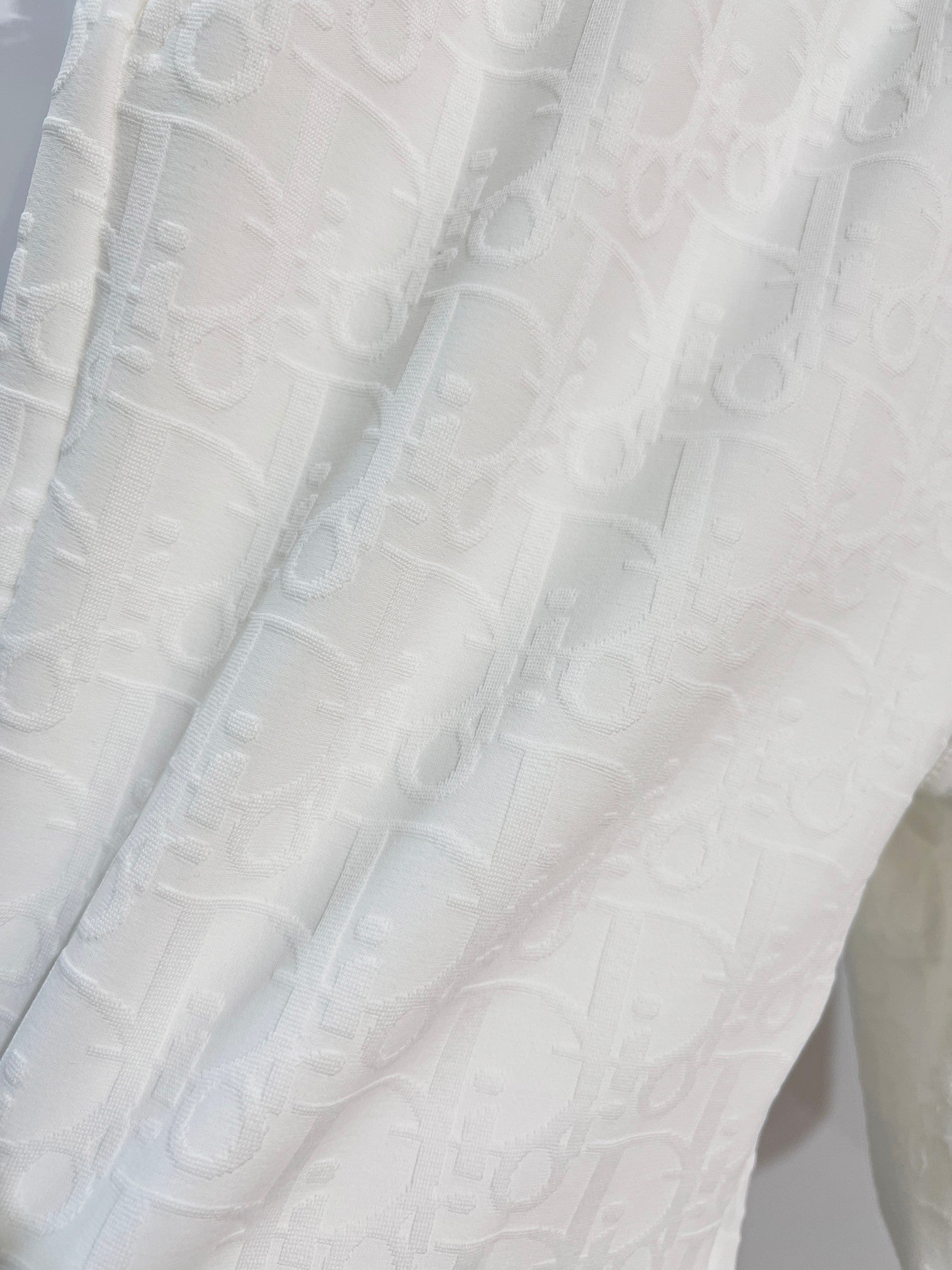 White shorts fabric with subtle allover logo-style texture