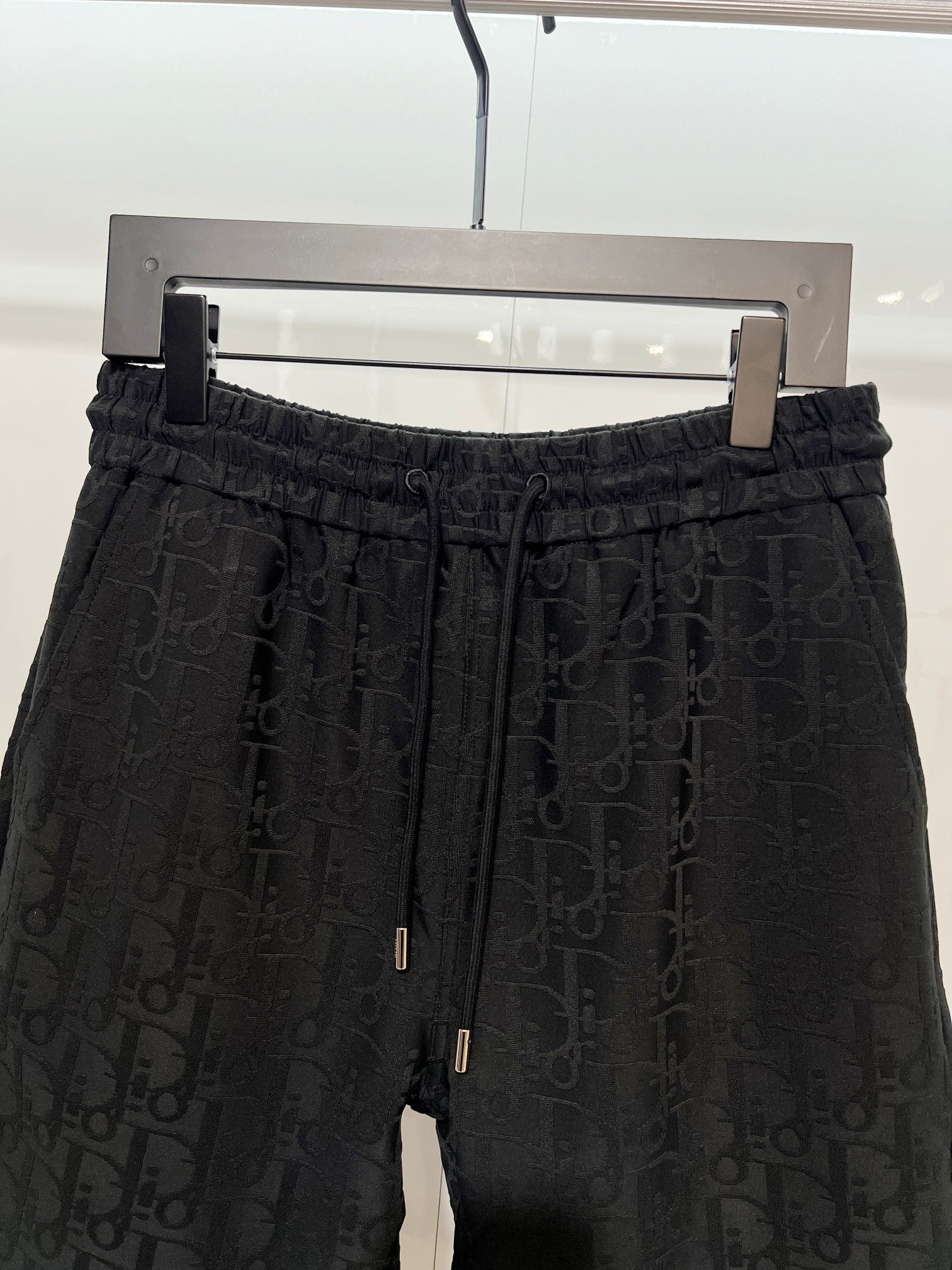 Black Dior monogram shorts, front view with elastic waist and drawstring cords