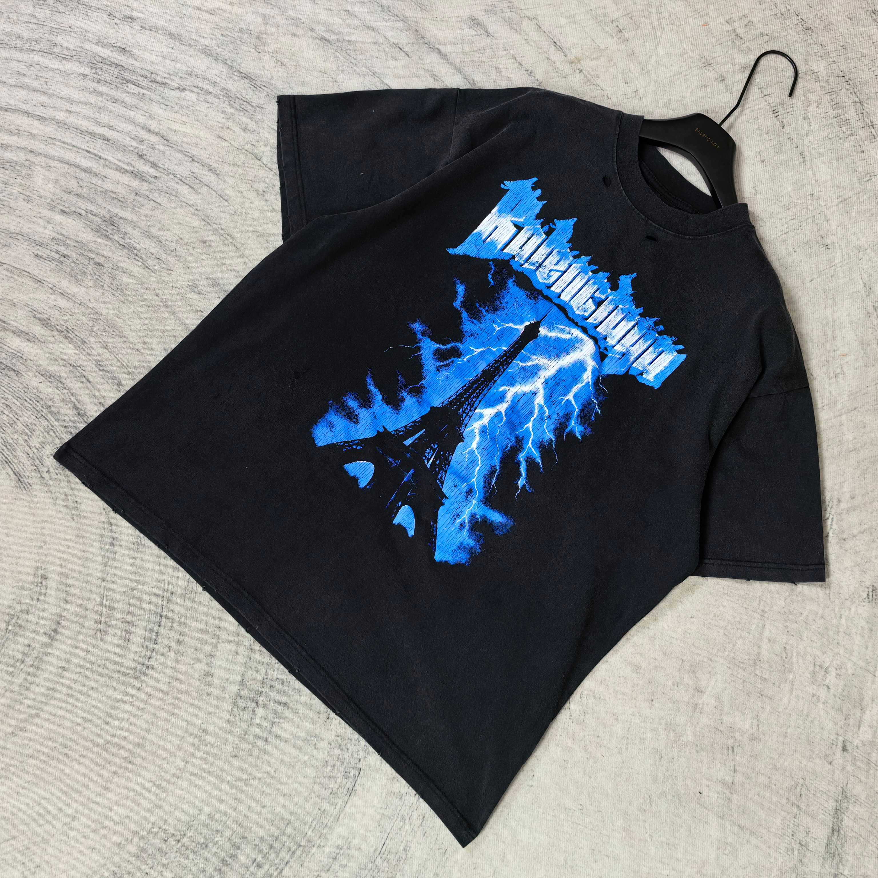 Balenciaga graphic T-shirt, dark folded; blue Eiffel lightning logo print on front