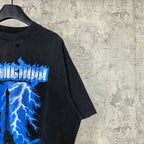Balenciaga T-shirt sleeve and shoulder detail; dark fabric with partial blue Eiffel print