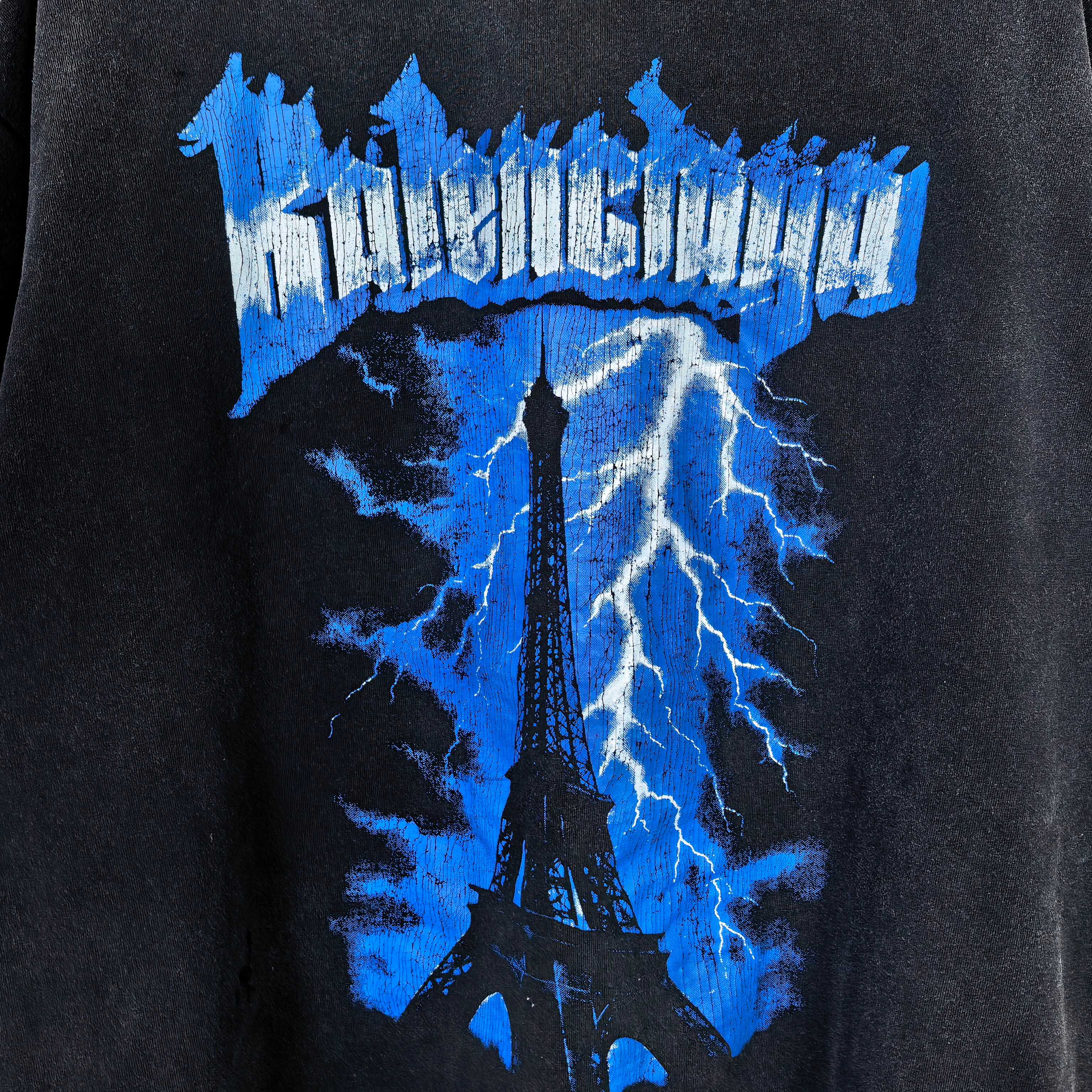 Balenciaga graphic T-shirt detail: blue Eiffel tower lightning print on dark fabric