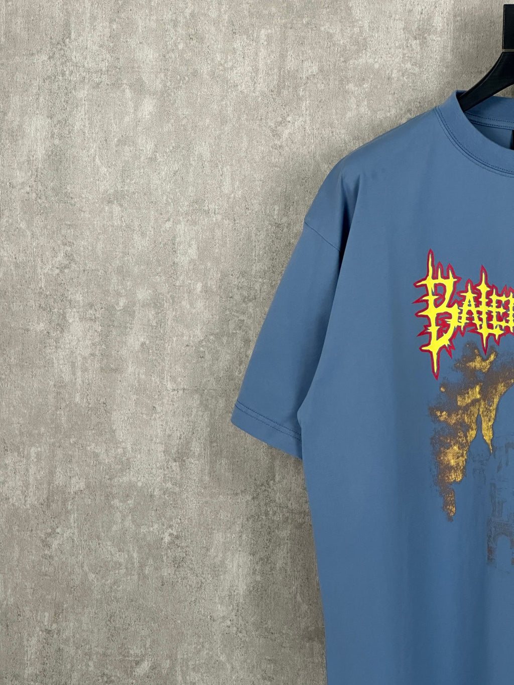Balenciaga blue T-shirt with colorful red and gold front graphic, short sleeves, side angle