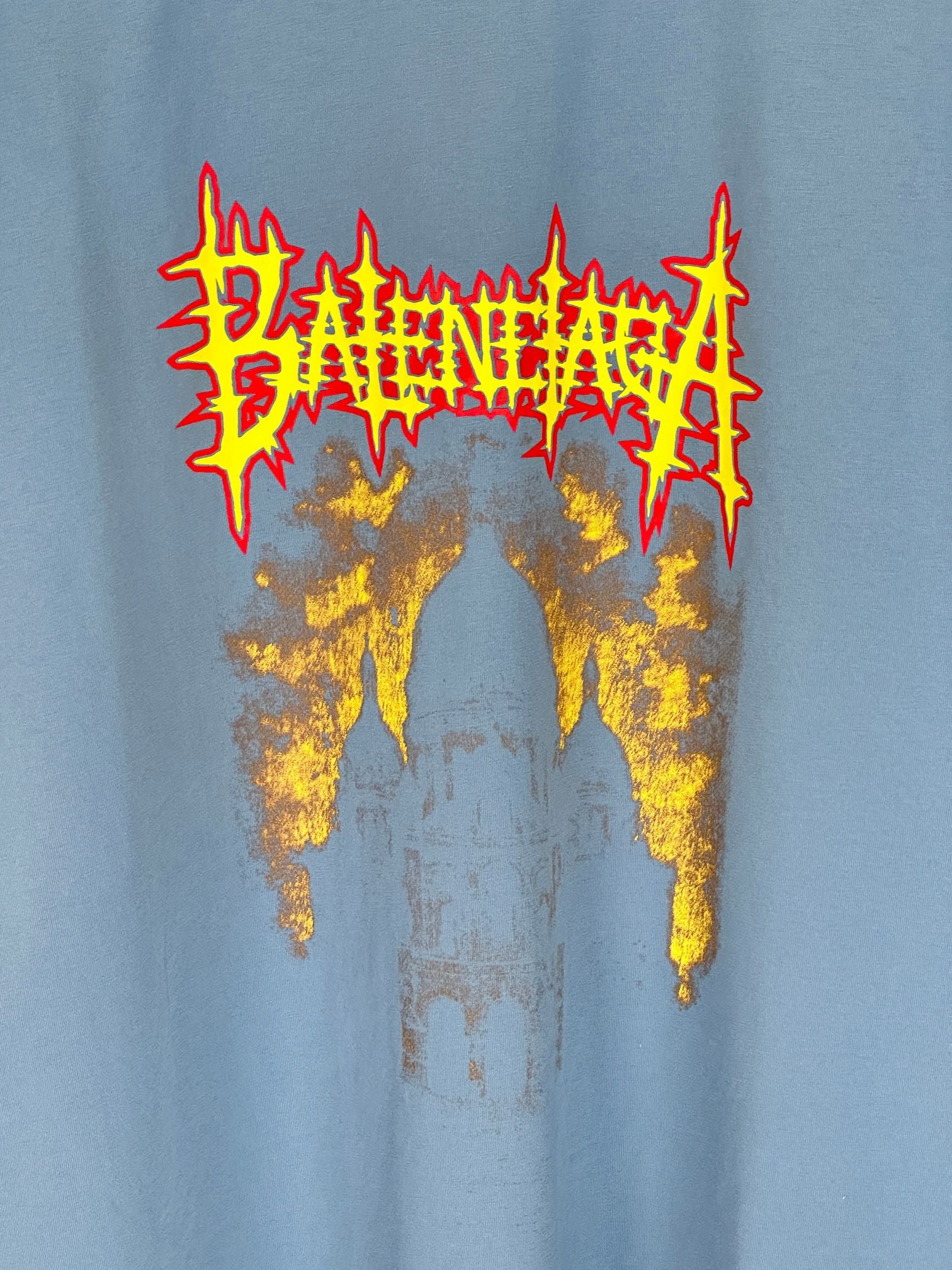 Balenciaga blue T-shirt front graphic close-up with red lettering and gold paint effect