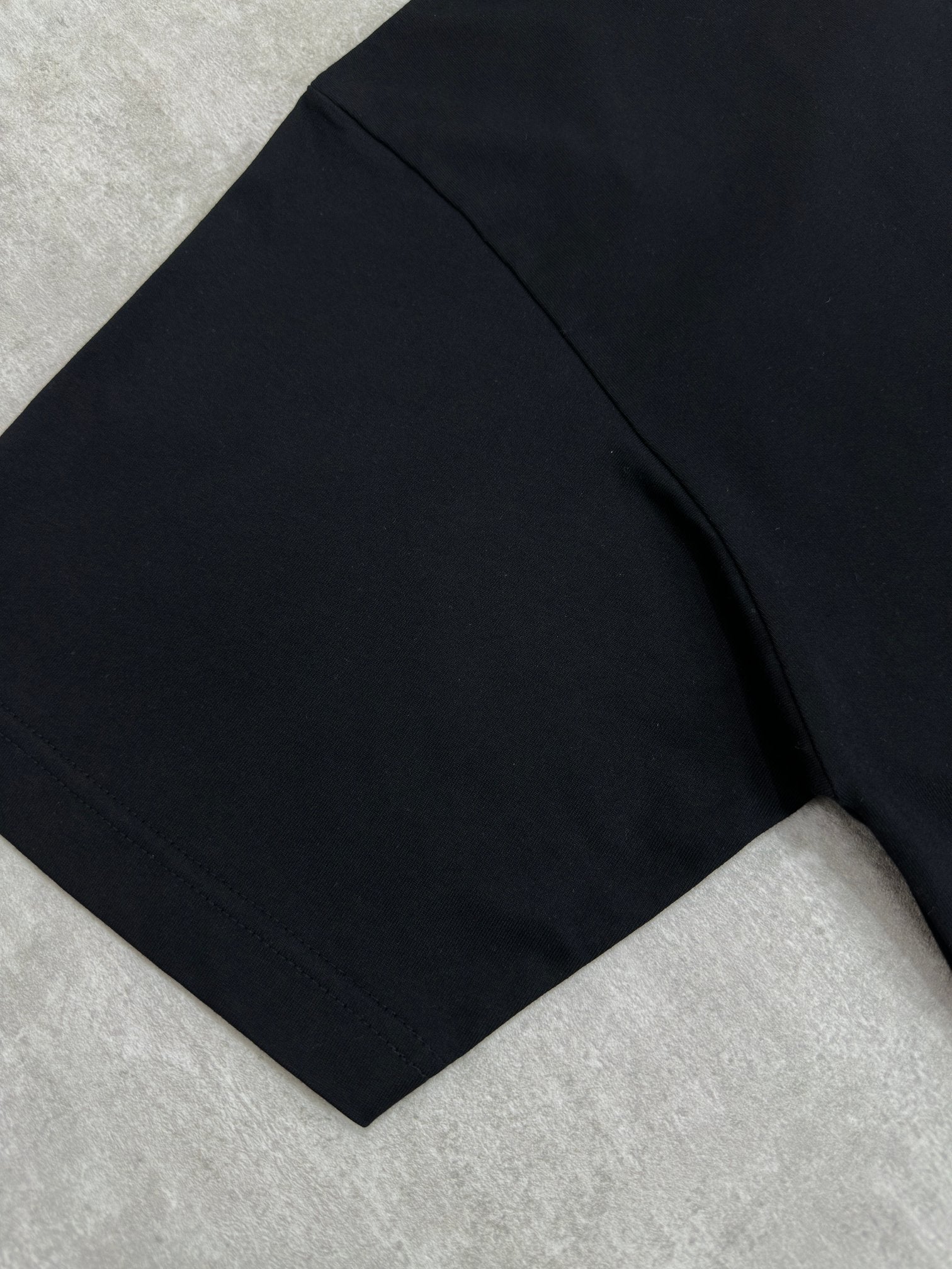 Balenciaga black T-shirt side view showing short sleeve and curved hem