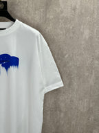 White T-shirt side view with blue paint graphic at the chest