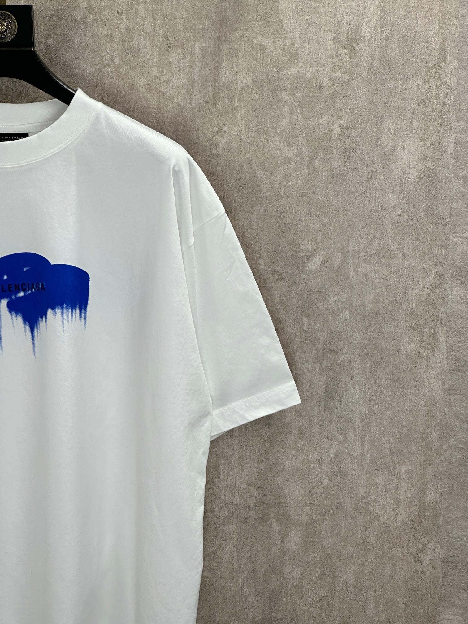 White T-shirt side view with blue paint graphic at the chest