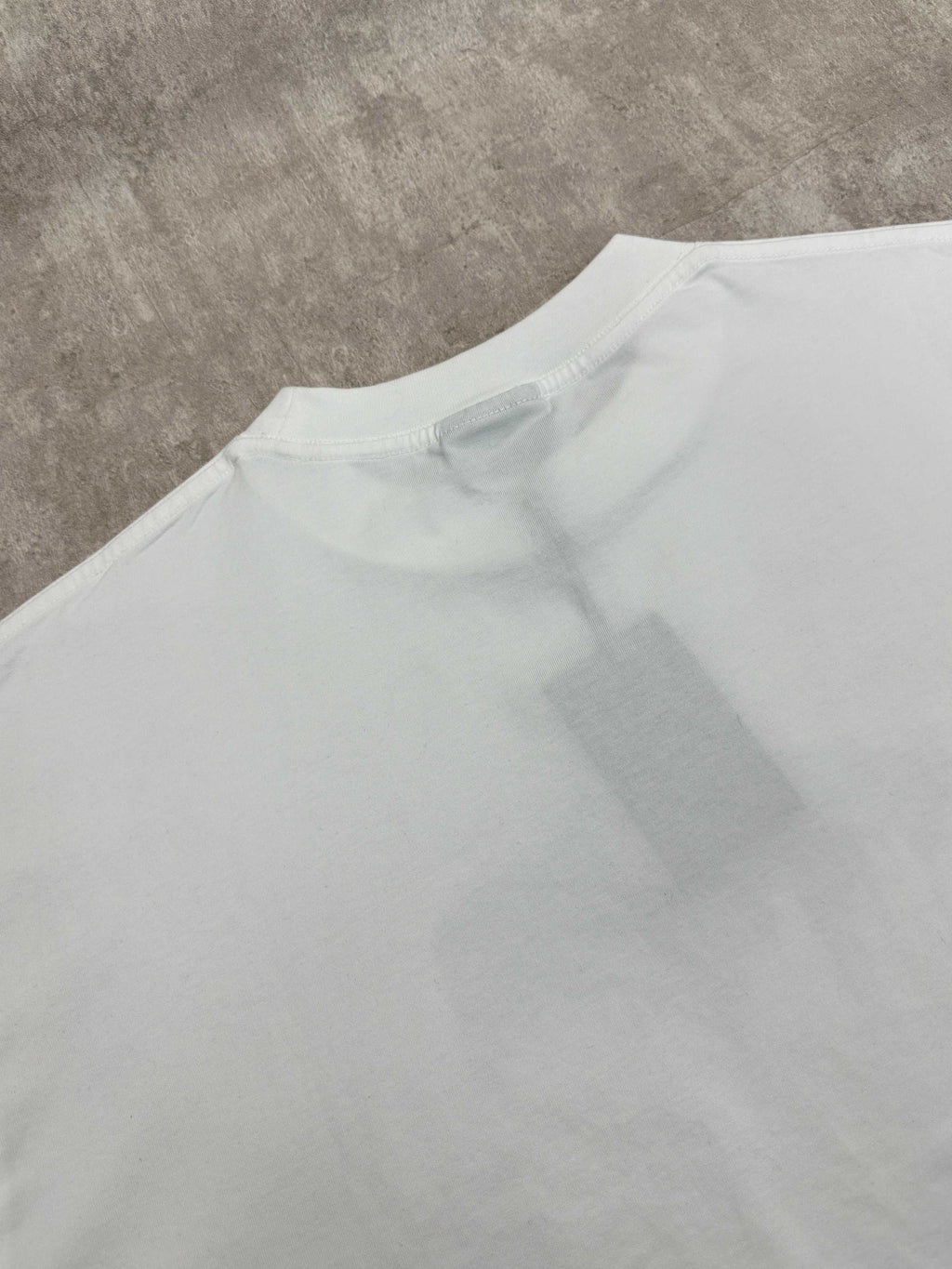 White T-shirt back close-up showing crew neck seam and relaxed fit