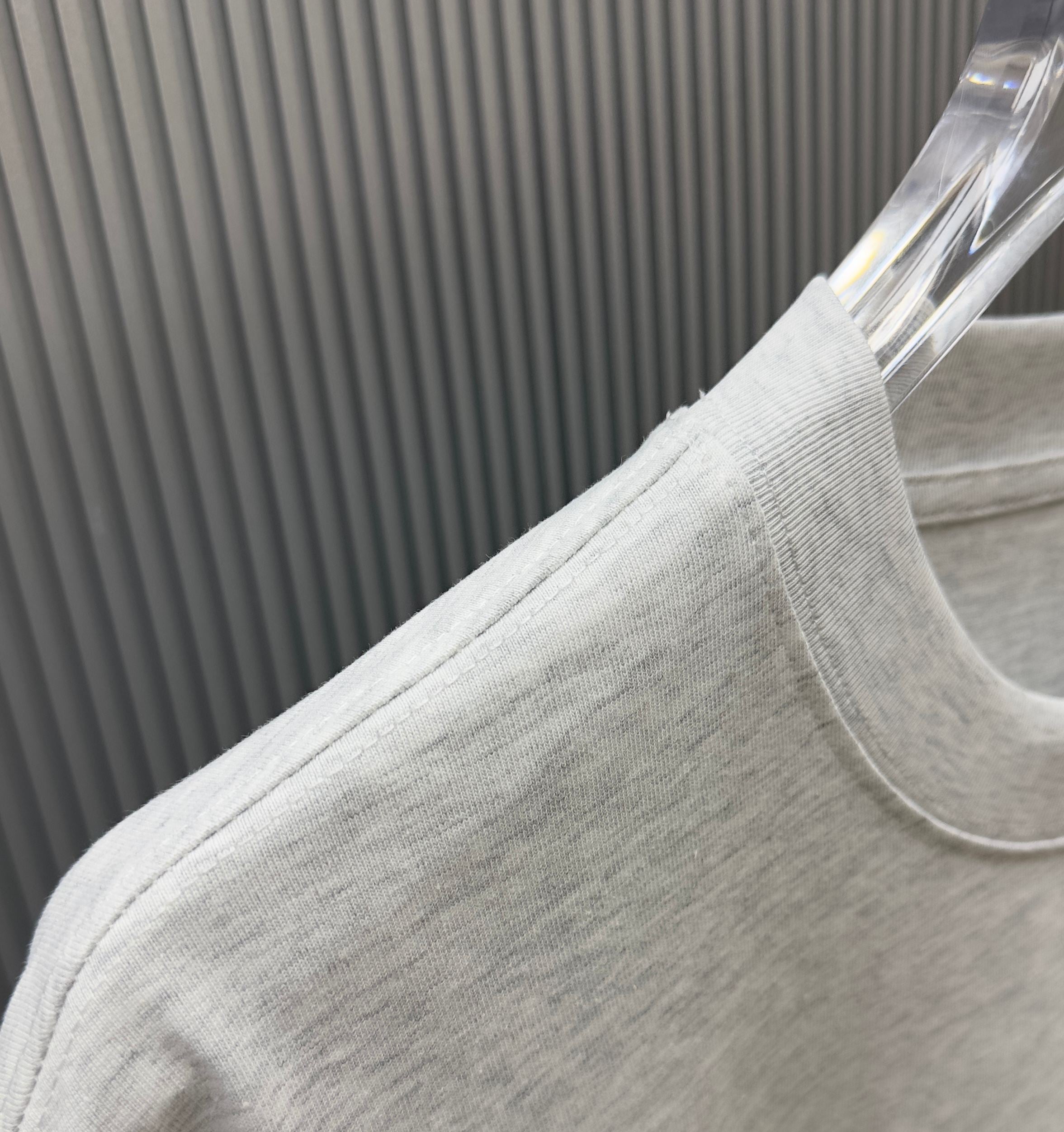 Light gray Givenchy T-shirt fabric close-up at shoulder and sleeve