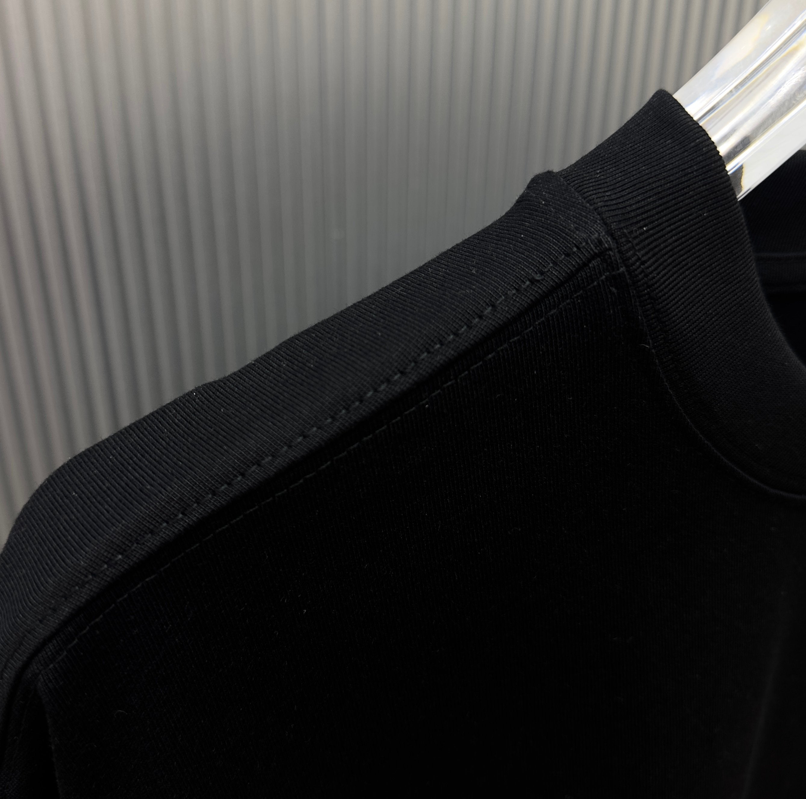 Black short-sleeve T-shirt sleeve cuff and shoulder seam close-up
